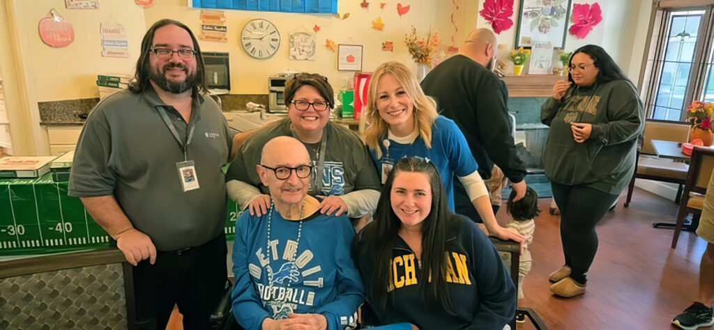 Group of people smiling together in a warm, supportive community setting