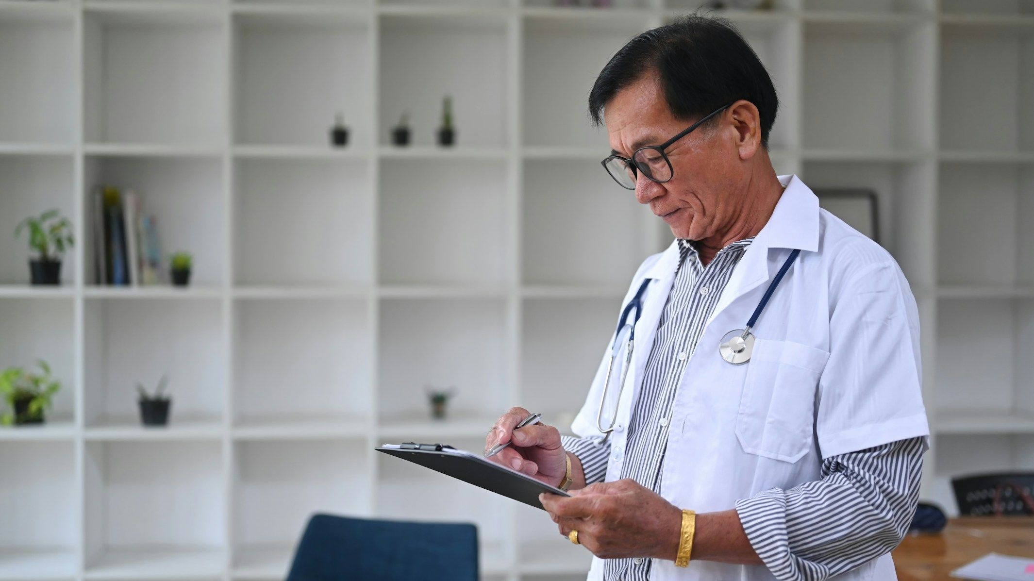 Doctor writing notes on a clipboard in a medical office