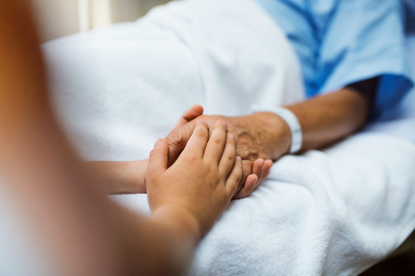 Healthcare provider gently holding a patient’s hand, offering reassurance and personal support during care
