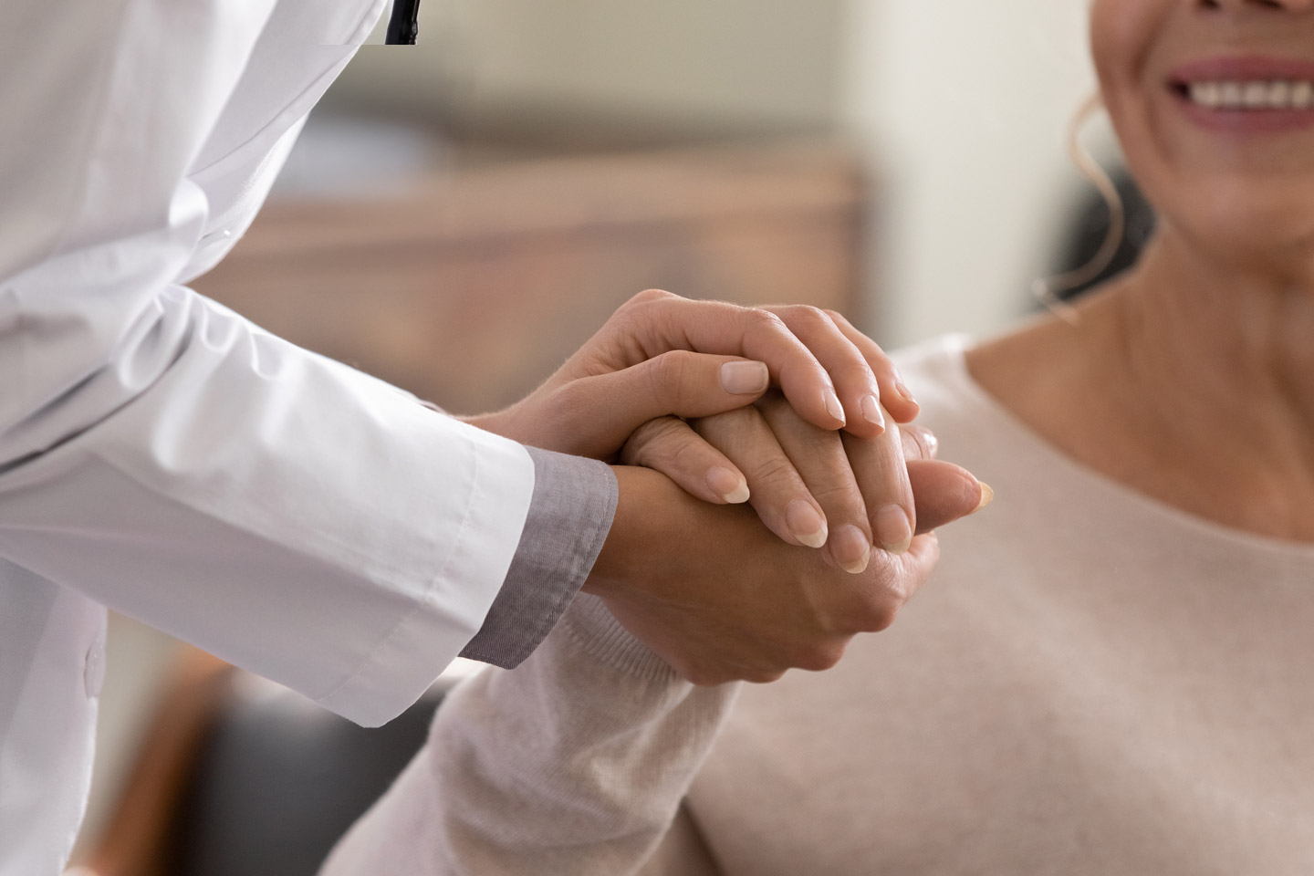 Healthcare provider gently holding a patient’s hand, offering reassurance and personal support during care