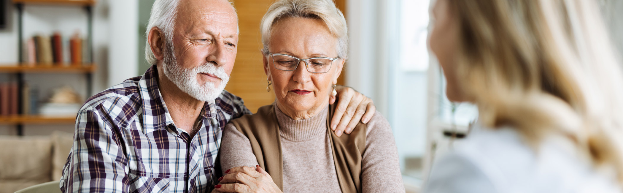 Older couple sitting closely together during a conversation with a care provider, seeking guidance and support in a shared moment