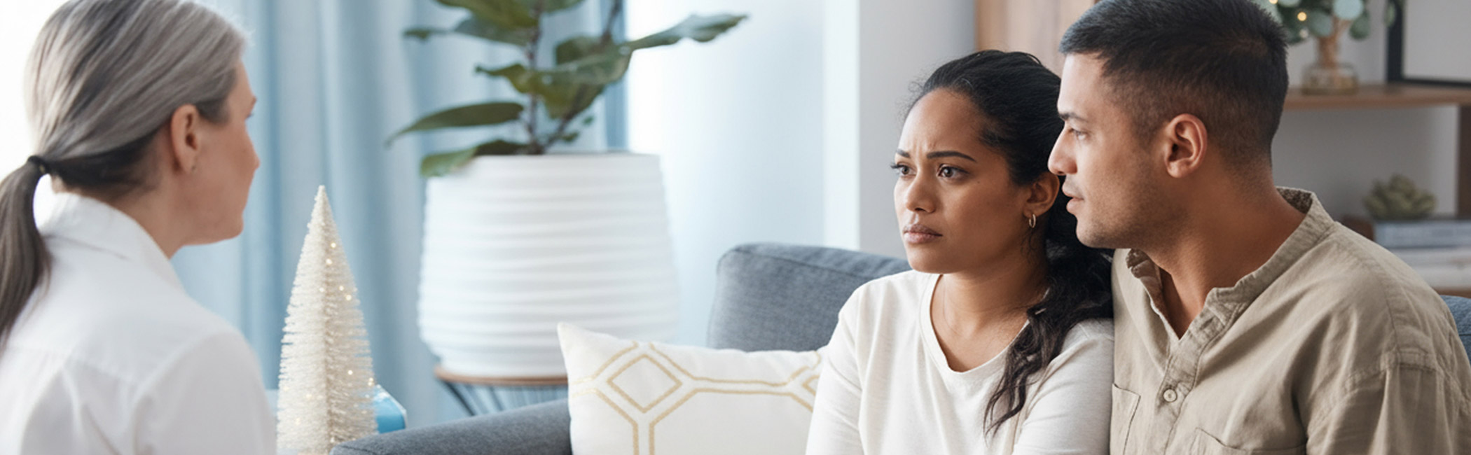 Care provider meeting with a couple at home, listening attentively and offering thoughtful guidance