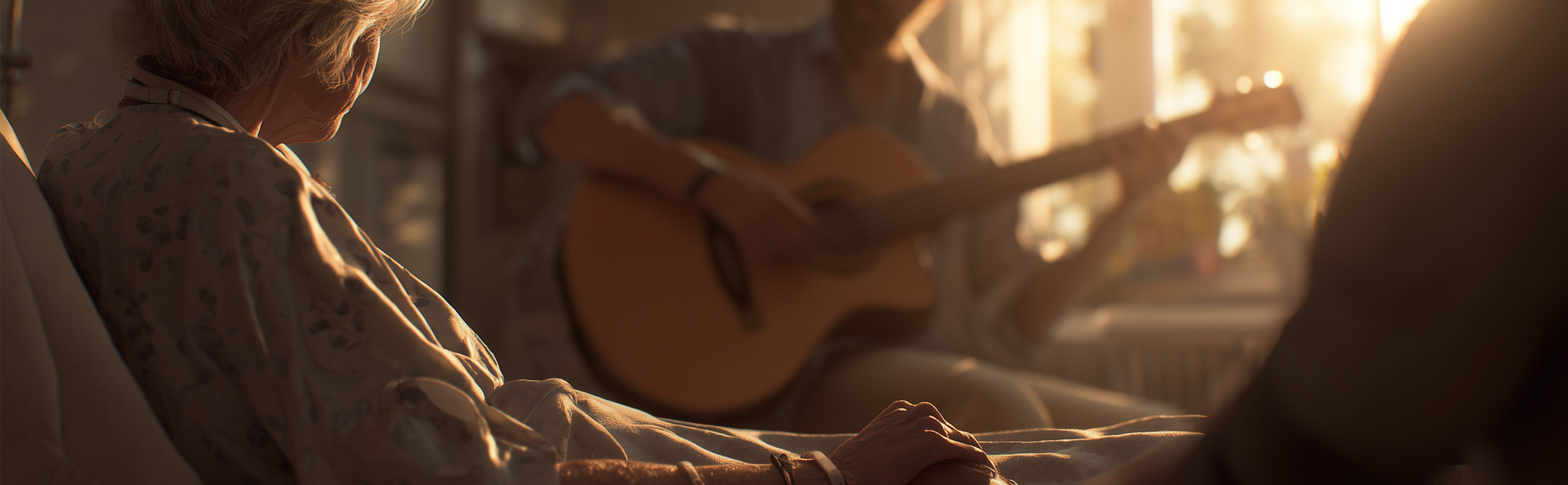 Patient resting in bed holding a loved one’s hand while music is played nearby, creating a peaceful and comforting environment
