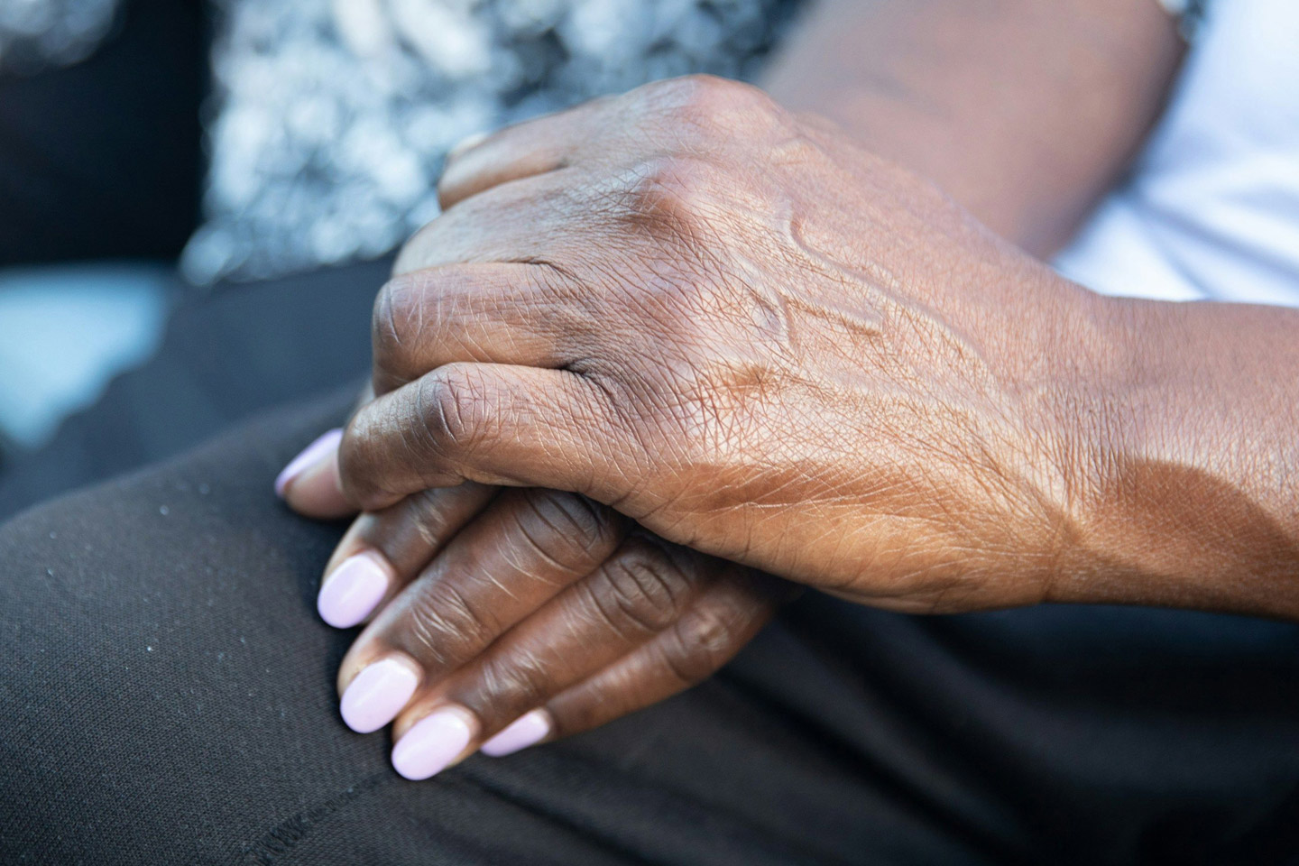 Close-up of an older woman’s hands resting together, reflecting a quiet moment of calm and presence