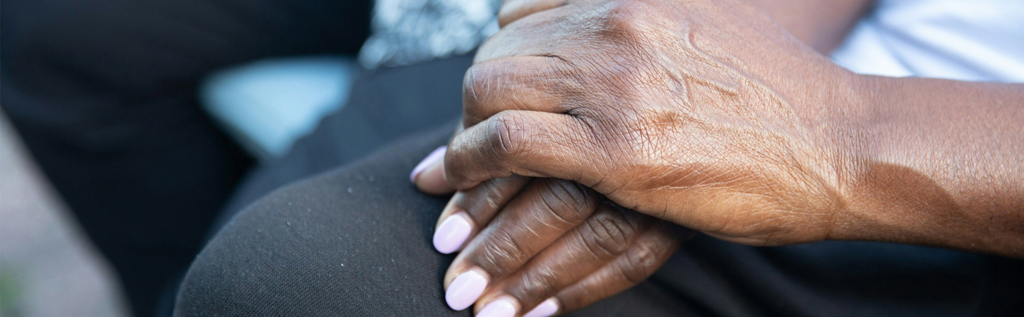 Close-up of an older woman’s hands resting together, reflecting a quiet moment of calm and presence
